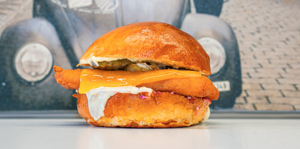 Fiskeburger med ost og remoulade foran en foodtruck