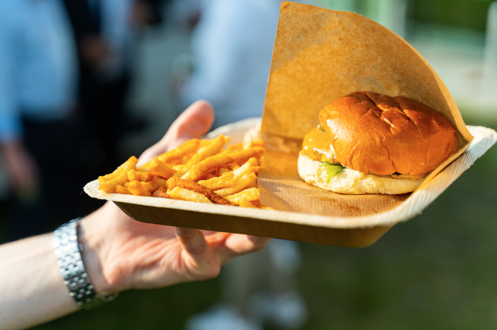 Burger og pommes frites serveret i papirbakke til et udendørs event